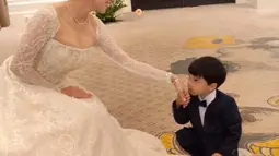 Dalam salah satu foto, Angel Karamoy menunjukkan sisi keibuannya saat berinteraksi dengan sang anak. Anak Angel Karamoy dari pernikahannya terdahulu menjadi bukti kasih sayangnya sebagai ibu. Momen haru terlihat ketika seorang bocah bersetelan tuxedo mencium tangannya dengan penuh hormat.  (Liputan6.com/IG/@realangelkaramoy)