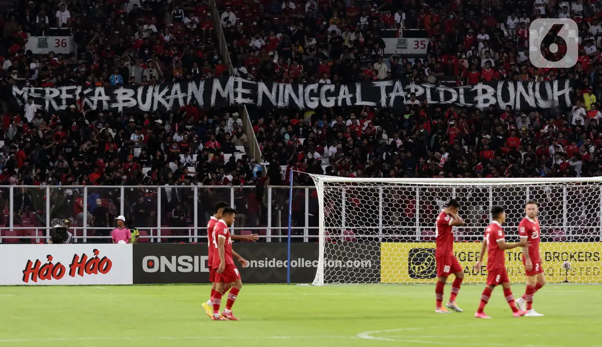 Pendukung timnas Indonesia membentang spanduk bernada keprihatinan saat menyaksikan laga kualifikasi Grup A Piala AFF 2022 antara Indonesia melawan Kamboja di di Stadion Utama Gelora Bung Karno, Jakarta, Jumat (23/12/2022). Mereka menyuarakan pengusutan tuntas kasus atas Tragedi Kanjuruhan yang terjadi pada awal Oktober 2022 lalu. (Liputan6.com/Helmi Fithriansyah)