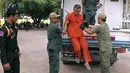 Yem Chrin (tengah) turun dari mobil kepolisian saat tiba di Pengadilan Provinsi Battambang,Kamboja,Kamis (3/12). Yem Chrin merupakan seorang tabib yang tinggal disuatu desa terpencil di Kamboja. (REUTERS/Stringer)