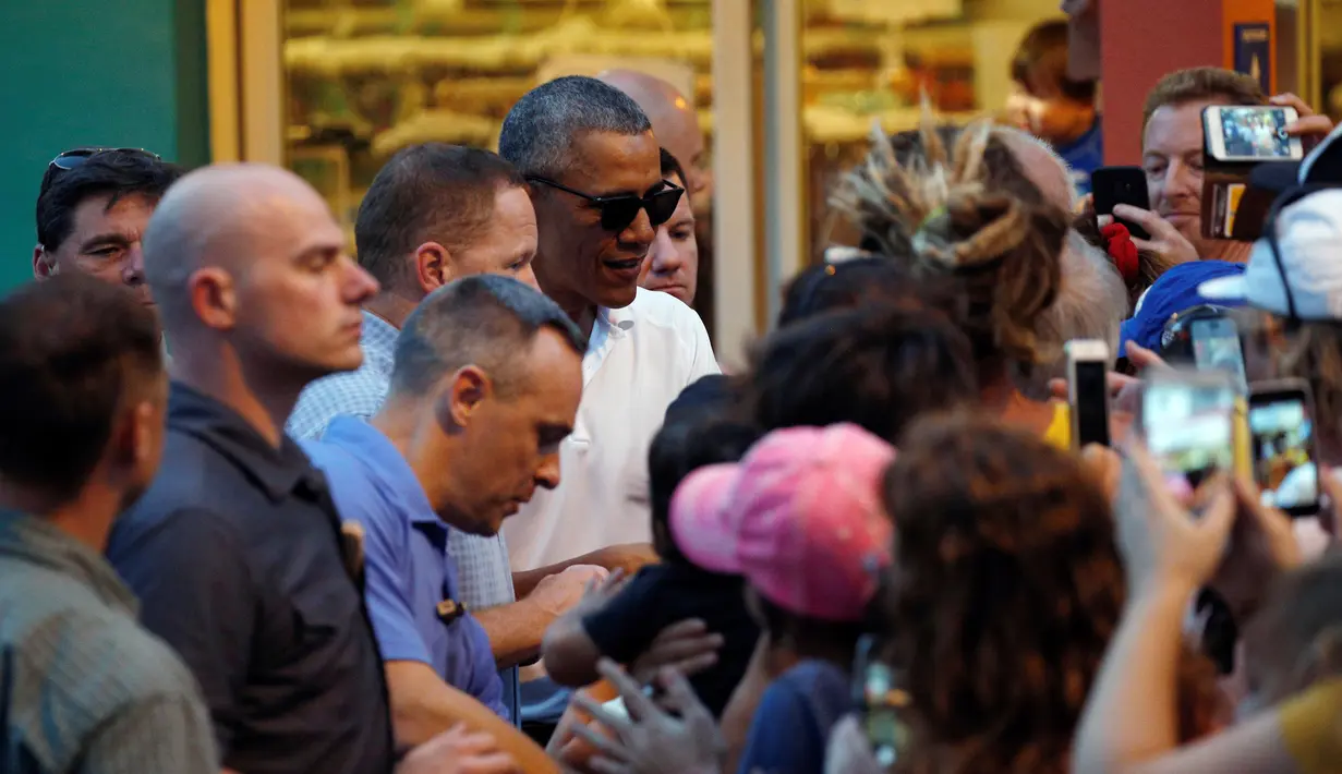 Presiden AS Barack Obama berbincang dengan warga setelah mengantre untuk membeli es serut saat berkunjung ke Island Ice ketika berlibur di Kailua, Hawaii, AS, AS, (24/12). (REUTERS/Kevin Lamarque)