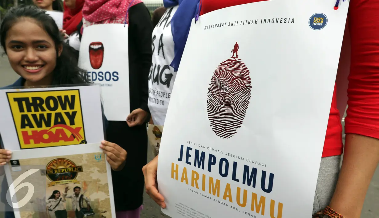 Mafindo menunjukan poster di hari bebas kendaraan bermotor di kawasan Thamrin, Jakarta, Minggu (22/1). Aksi tersebut digelar untuk memberikan pemahaman kepada masyarakat agar berhati-hati dan menyaring informasi yang beredar. (Liputan6.com/JohanTallo)