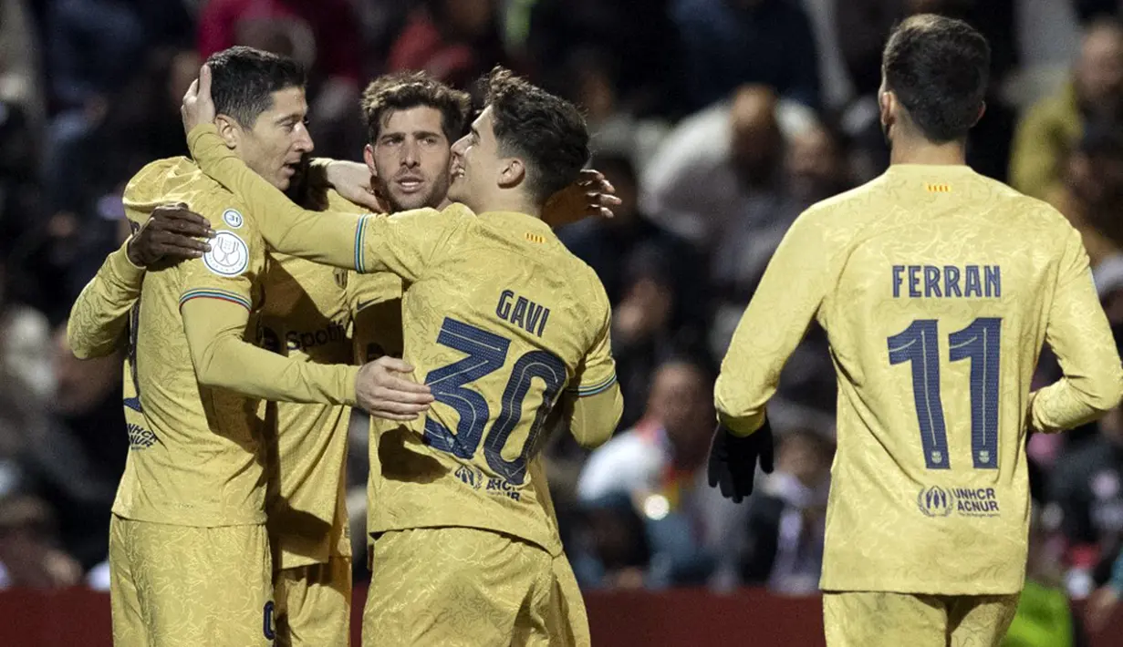 Pemain Barcelona Robert Lewandowski (kiri) merayakan dengan rekan satu timnya usai mencetak gol ke gawang AD Ceuta pada pertandingan sepak bola babak 16 besar Copa del Rey di Stadion Alfonso Murube, Ceuta, Spanyol, 19 Januari 2023. Barcelona mengalahkan AD Ceuta dengan skor 5-0. (JORGE GUERRERO/AFP)