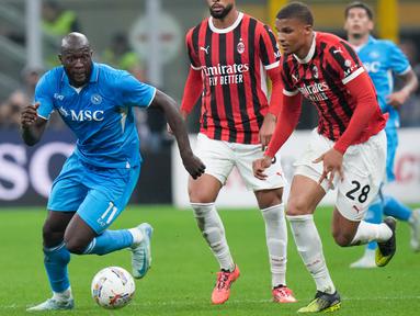 Pemain Napoli, Romelu Lukaku, melewati pemain AC Milan sebelum mencetak gol apik pada laga Liga Italia di Stadion San Siro, Rabu 30 Oktober 2024. (AP Photo/Luca Bruno)