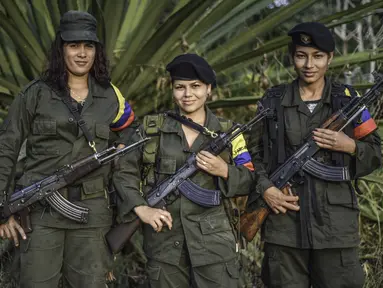 Tiga gerilyawati FARC berpose di kamp Magdalena Medio, Kolombia (15/3/2016). Gerilyawati FARC dikenal lebih sadis terhadap musuh daripada pasukan gerilyawan. (AFP Photo/Luis Acosta)