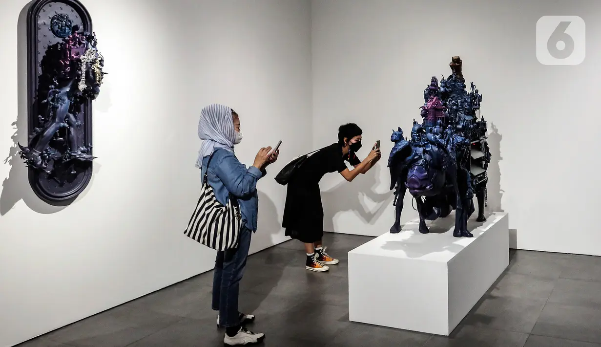 Pengunjung mengambil gambar karya seni kontemporer yang sedang dipamerkan di Distrik Seni, Gedung Sarinah, Jakarta Pusat, Senin (13/6/2022). Di tengah situasi transisi pandemi ke endemi, geliat seni semakin terbuka. (Liputan6.com/Johan Tallo)