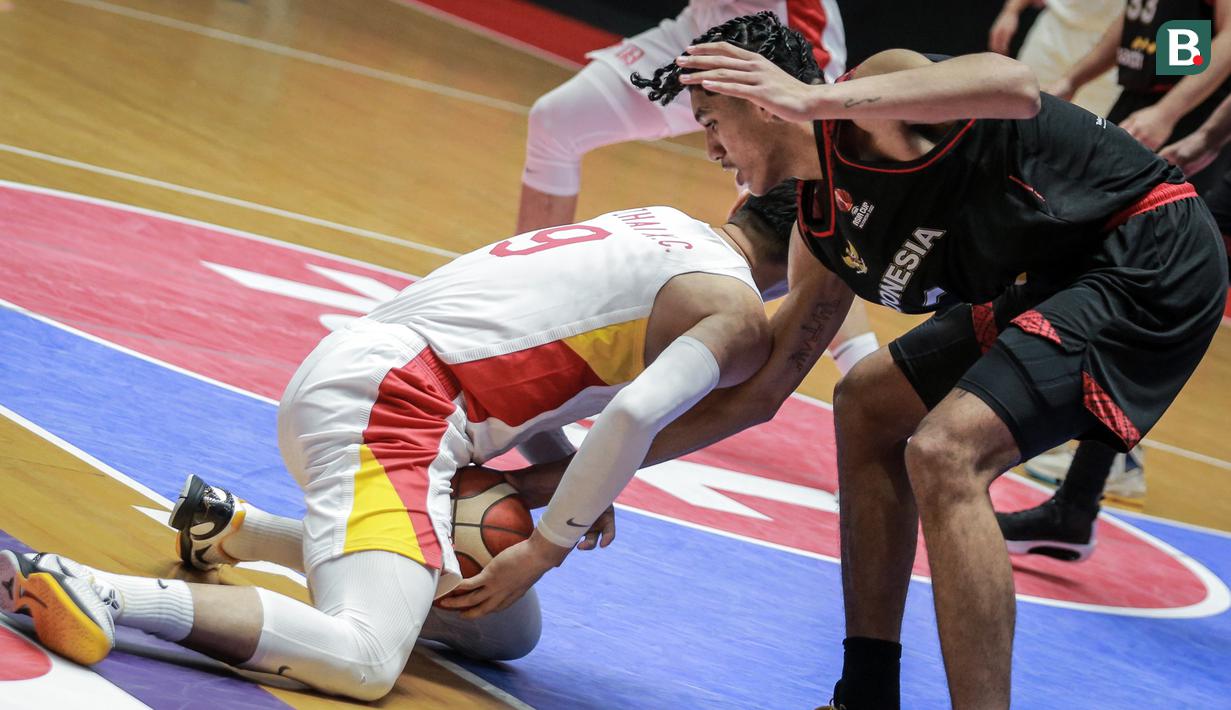 Pemain Timnas Basket Indonesia, Derrick Michael Xzavierro (kanan) berusaha merebut bola pemain Timnas Basket China, Zhai Xiaochuan saat laga playoff perempat final FIBA Asia Cup 2022 di Istora Senayan, Jakarta, Senin (18/07/2022). (Bola.com/Bagaskara Lazuardi)