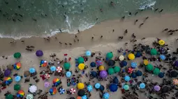 Orang-orang menyejukkan diri di pantai Arpoador saat terjadi gelombang panas di Rio de Janeiro, Brasil, Rabu, 15 November 2023. (AP Photo/Bruna Prado)
