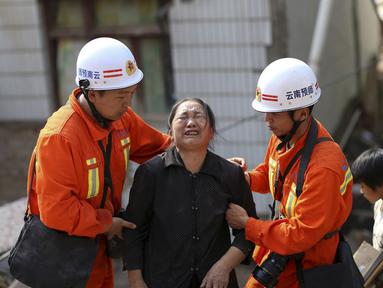 Petugas penyelamat membantu seorang wanita yang menangis di zona gempa di Longtoushan, provinsi Yunan, Tiongkok, (6/8/2014). (REUTERS/Stringer)