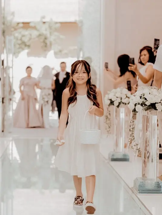 Gempita Nora Marten merupakan anak dari Gisela dan Gading Marten. Gempi yang beranjak besar memiliki paras cantik yang makin mirip dengan sang Mama. Ini merupakan momen Gempi di pernikahan Gritte Agatha, dalam balutan dress simpel berwarna putih. [Foto: Instagram/gisel_la]