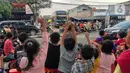 Sejumlah anak berjoget sambil merekam fenomena klakson bus telolet yang kembali marak di Jalan Raya Ciledug, Tangerang, Minggu (18/6/2023). (Liputan6.com/Angga Yuniar)