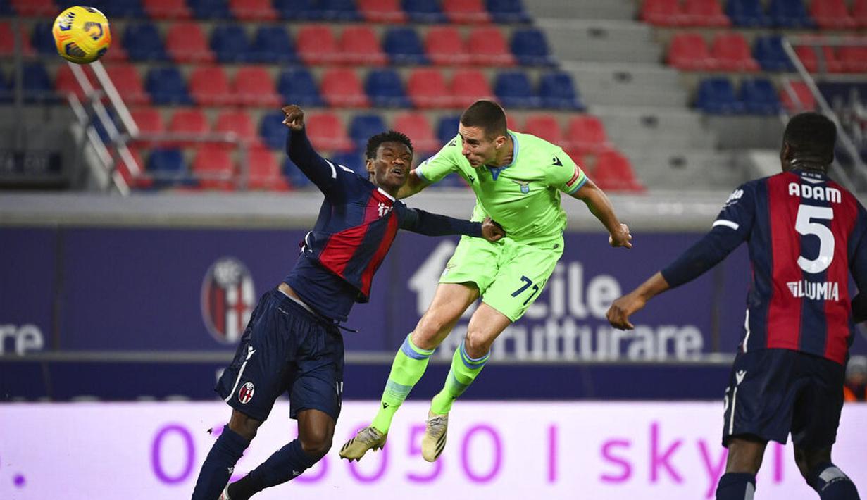 Pemain Lazio, Adam Marusic , duel udara dengan pemain Bologna, Ibrahima Mbaye, pada laga Liga Italia di Stadion Renato Dall’Ara, Minggu (28/2/2021). Lazio takluk dengan skor 2-0. (Massimo Paolone/LaPresse via AP)