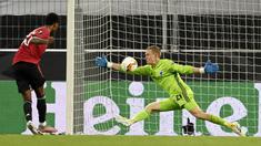 Kiper Copenhagen, Karl-Johan Johnsson, menghalau bola tendangan penyerang Manchester United, Marcus Rashford, pada laga Liga Europa di Stadion Rhein Energie, Senin (10/8/2020). MU menang tipis 1-0 atas Copenhagen. (Sascha Steinbach/Pool via AP)