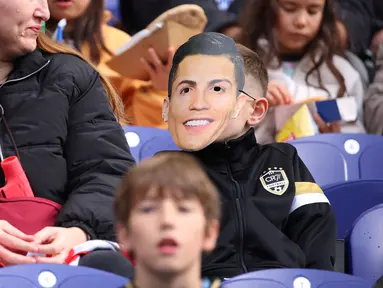 Seorang suporter mengenakan topeng Cristiano Ronaldo saat menyaksikan laga Grup F Kualifikasi Piala Dunia 2026 antara Portugal melawan Armenia di Dragao Stadium, Porto, Minggu (16/11/2025) waktu setempat. (AP Photo/Luis Vieira)