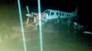 Pesawat terbang jenis twin otter yang tengah parkir diterjang banjir bandang di lapangan terbang di Sentani, Kabupaten Jayapura, Papua, Minggu (17/3). Berdasarkan data BNPB, banjir bandang tersebut mengakibatkan 58 orang tewas. (HO/BNB/AFP)