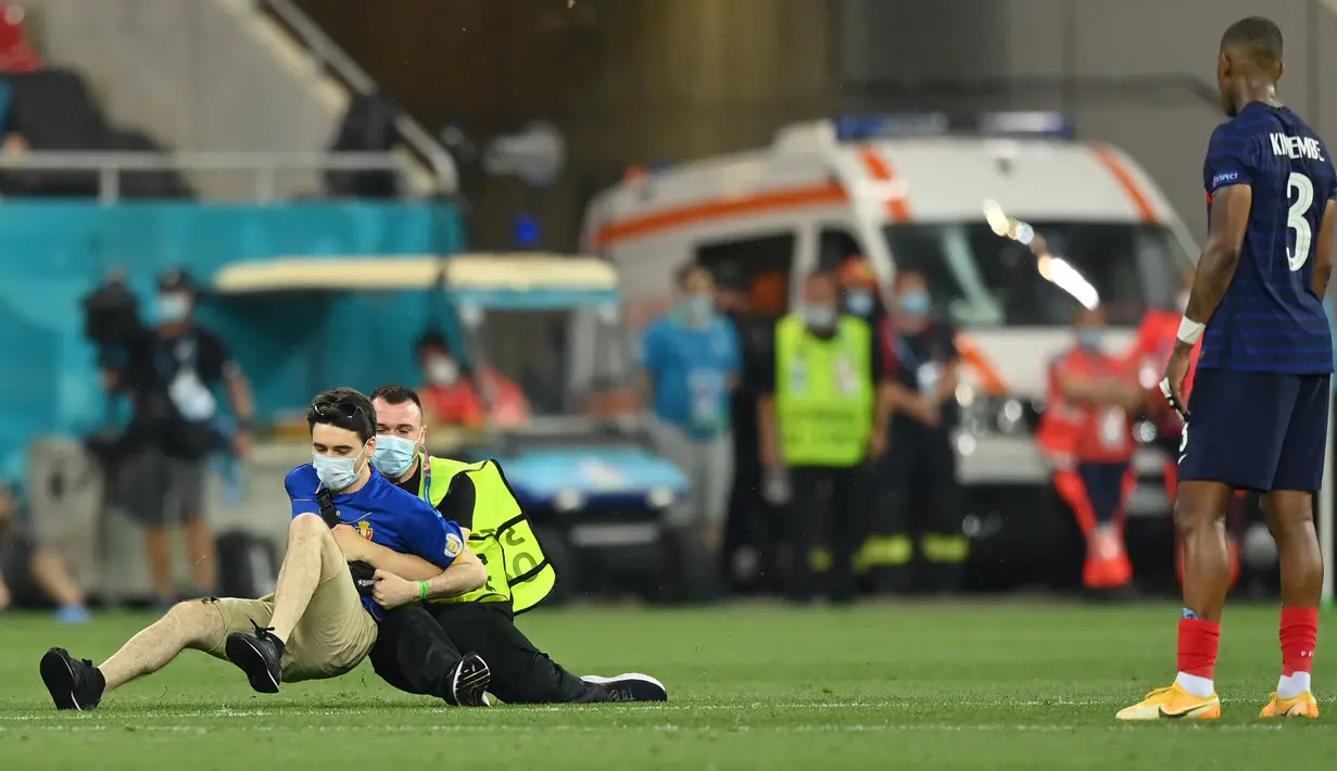 Seorang petugas keamanan menahan seorang penyusup lapangan selama pertandingan sepak bola babak 16 besar UEFA EURO 2020 antara Prancis melawan Swiss yang berlangsung di National Arena, Bucharest pada 28 Juni 2021. (AFP/Pool/Justin Setterfield)