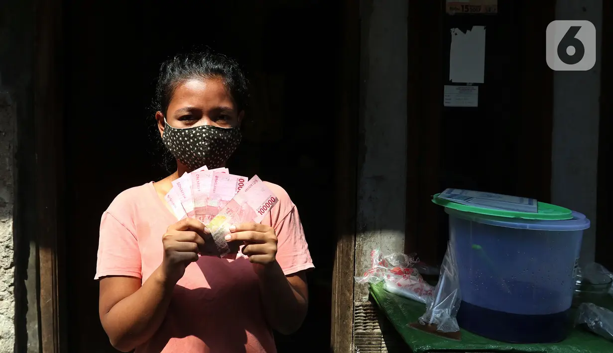 Warga menunjukkan Bantuan Sosial Tunai (BST) yang disalurkan petugas pos dari rumah ke rumah di kawasan Kebon Jahe, Jakarta Pusat, Rabu (21/7/2021). BST senilai Rp 600 ribu disalurkan untuk dua periode yakni bulan Mei-Juni. (Liputan6.com/Herman Zakharia)