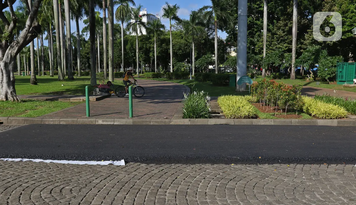 Contoh aspal lintasan Formula E terlihat di kawasan Monas, Jakarta, Minggu (23/2/2020). Aspal untuk sirkuit Formula E di uji coba di Monas, lokasi pengaspalan itu berada di Monas bagian timur. Pengaspalan dilakukan dengan dua metode, sandsheet dan geotextile. (Liputan6.com/Herman Zakharia)