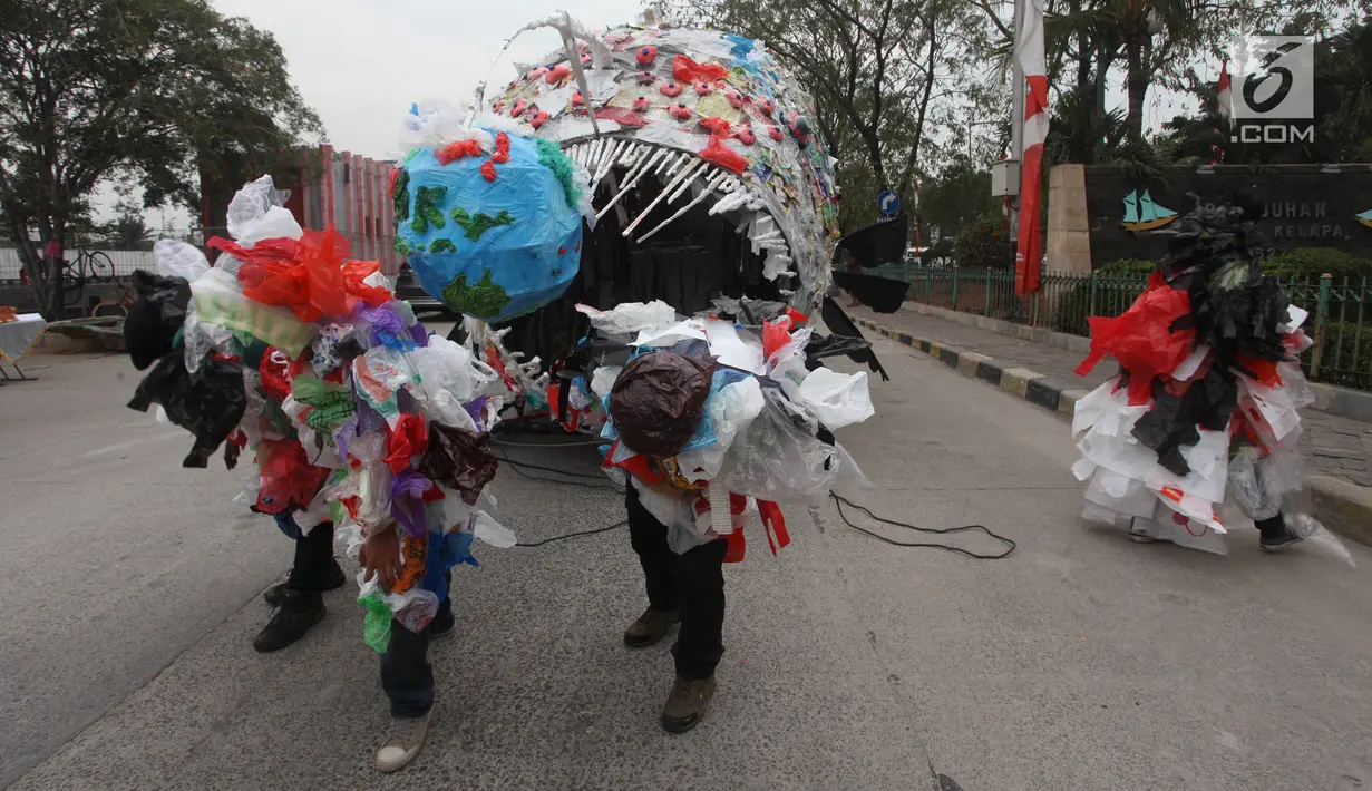 Aktivis pemerhati lingkungan mengarak monster plastik saat aksi Tolak Penggunaan Plastik Sekali Pakai di Pelabuhan Sunda Kelapa, Jakarta, Sabtu (20/7/2019). Monster plastik itu berupa rangka berbentuk ikan jenis anglerfish yang ukurannya sebesar mobil sampah. (Liputan6.com/Herman Zakharia)
