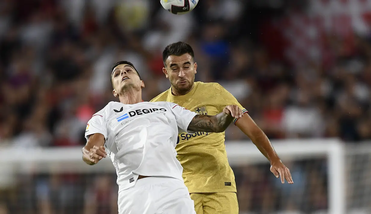 Gelandang Sevilla, Erik Lamela berebut bola udara dengan bek Barcelona, Eric Garcia selama pertandingan lanjutan La Liga Spanyol di Seville, Spanyol, Sabtu (3/9/2022). Barcelona menang telak atas Sevilla 3-0. (AP Photo/Jose Breton)