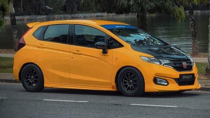 Warna kuning dengan sedikit ornamen biru pada kaca depan membuatnya sangat kental dengan nuansa rumah modifikasi Spoon yang biasa diterapkan pada mobil balap Honda.  Perpaduan warna kuning dan hitam dengan kap karbon membuatnya terlihat seperti mobil balap jalanan.  (Sumber: Instagram/@jazzfitmalaysia)