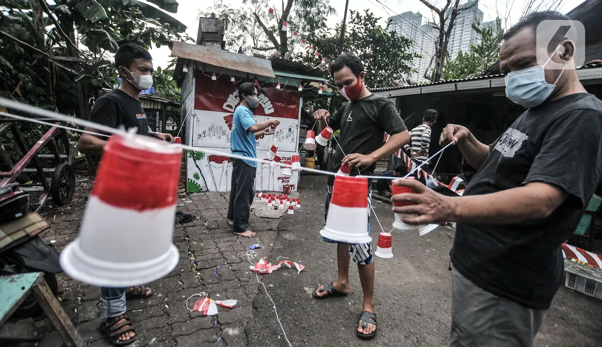 Warga menyelesaikan pemasangan ornamen bernuansa Kemerdekaan RI di "Kampung Merdeka" RW 04 Kelurahan Kebon Melati, Tanah Abang Jakarta, Rabu (11/8/2021). Kampung Merdeka dihias dengan mural dan beragam ornamen merah putih dalam rangka menyambut Hari Kemerdekaan ke-76 RI (merdeka.com/Iqbal S Nugroho)