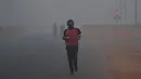 Pejalan kaki berolahraga di tengah kondisi kabut asap tebal di New Delhi (2/11). Tingkat kabut melonjak selama musim dingin di Delhi, ketika kualitas udara melampaui tingkat aman Organisasi Kesehatan Dunia. (AP Photo/Money Sharma)