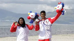 Atlet modern pentathlon, Muhammad Taufik dan Dea Salsabila, berpose usai meraih medali pada nomor beach triathle individual SEA Games 2019 di Subic, Jumat (6/12). Taufik meraih perunggu dan Dea meraih emas. (Bola.com/M Iqbal Ichsan)