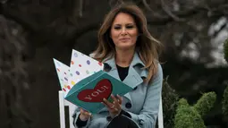 Ekspsresi istri Presiden AS Melania Trump saat membacakan buku untuk anak-anak saat perayaan Easter Egg Roll di Gedung Putih, Washington (4/2). Perayaan Easter Egg Roll di Gedung Putih ini digelar setiap tahunnya. (AFP Photo/Nicholas Kamm)