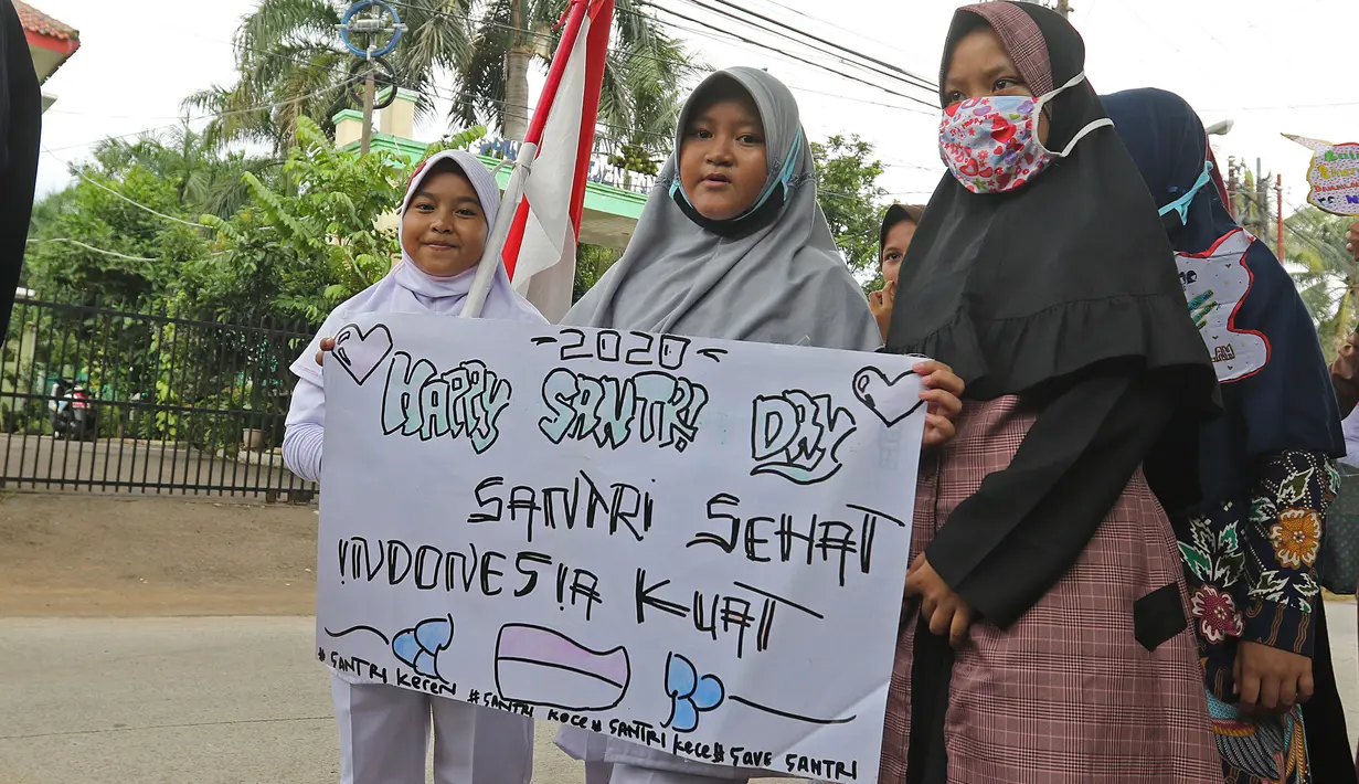 Sejumlah anak pengajian melakukan pawai di Jalan Raya Tapos, Depok, Jawa Barat, Kamis (22/10/2020). Pengajian Kampung Tapos menggelar pawai menyambut Hari Santri Nasional 2020 yang diperingati setiap tanggal 22 Oktober. (Liputan6.com/Herman Zakharia)