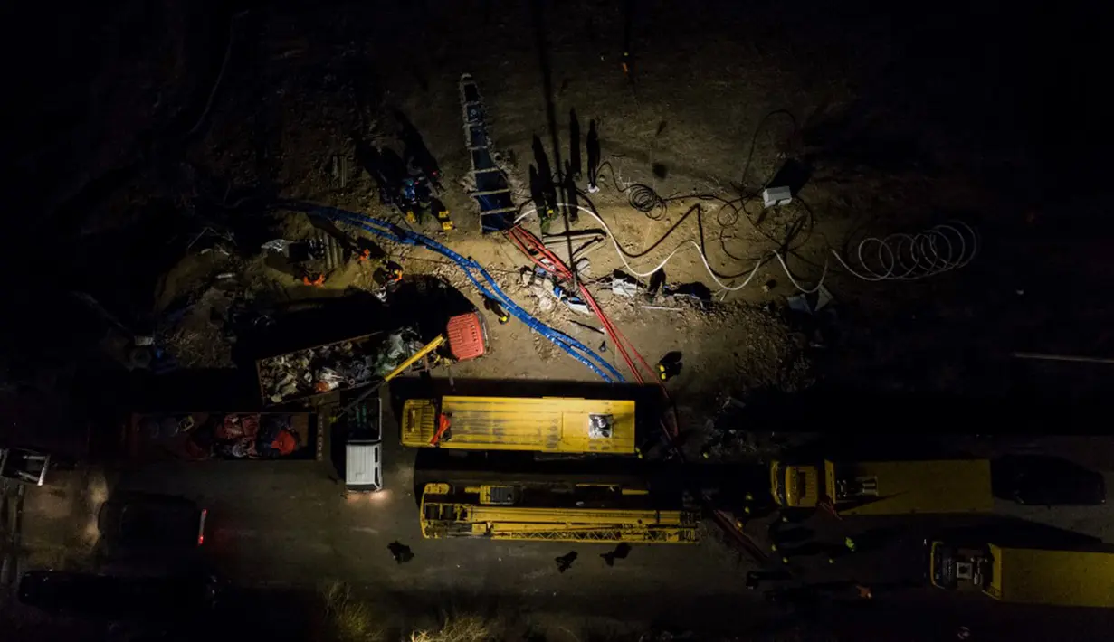 Tim penyelamat menggunakan pompa untuk mengalirkan air dari lubang bawah tanah saat operasi penyelamatan penambang yang terperangkap dalam tambang batu bara di Xiaoyi, Shanxi, China, 16 Desember 2021. Sebanyak 21 penambang terperangkap akibat banjir yang melanda Xiaoyi. (STR/CNS/AFP)