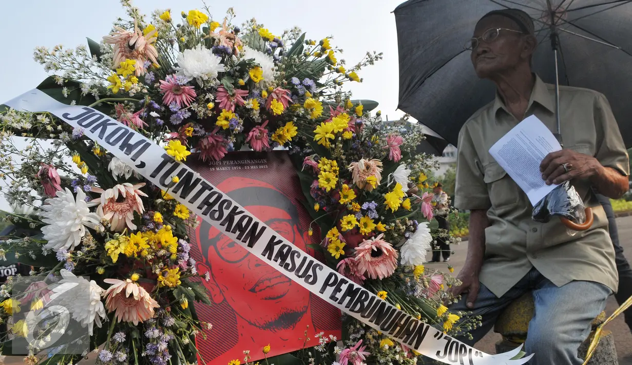 Sebuah karangan bunga bergambar Jopi dibawa saat aksi kamisan di depan Istana Negara, Jakarta, Kamis (2/7/15). Dalam aksinya mereka meminta kepada Jokowi untuk menuntaskan kasus pembunuhan Jopi. (Liputan6.com/Herman Zakharia)