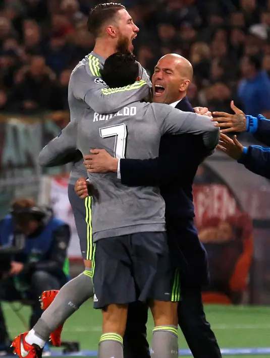 Gelandang Real Madrid, Cristiano Ronaldo melakukan selebrasi dengan pelatih Zinedine Zidane dan bek Sergio Ramos usai mencetak gol kegawang AS Roma pada leg pertama 16 besar Liga Champions di Stadion Olimpico, Italia (18/2). (REUTERS/Alessandro Bianchi)