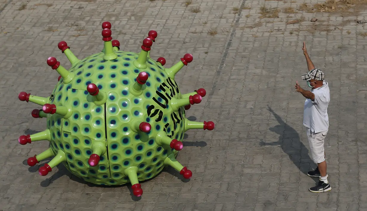 Desainer mobil India K. Sudhakar Yadav berdiri di samping mobil bertema Coronavirus di museum yang ia buat sebagai bagian dari kampanye kesadaran yang bertujuan mencegah penyebaran virus di Hyderabad, India, Selasa (7/4/2020). (AP Photo/Mahesh Kumar A.)