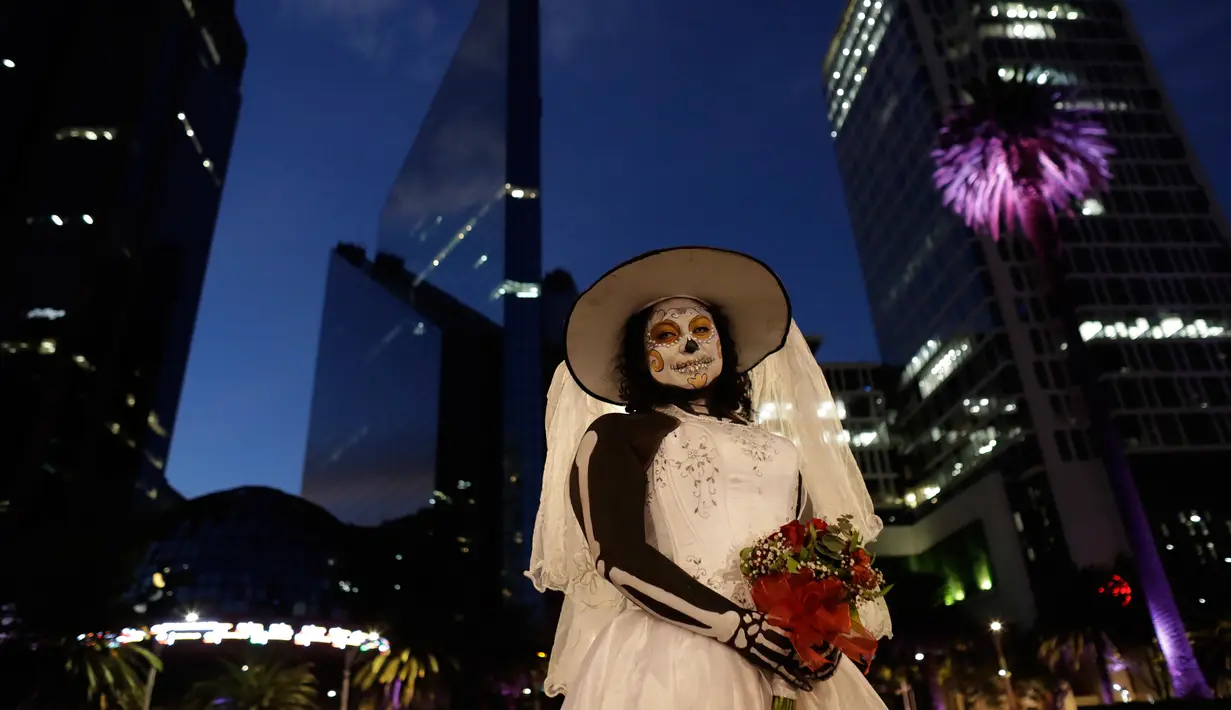 Montserrat Ramirez, berpakaian seperti pengantin kerangka selama Prosesi Grand Catrinas bagian dari perayaan Day of The Dead, di Mexico City, Minggu (22/10). Acara ini diadakan untuk mengenang mendiang kerabat dan sahabat. (AP/Rebecca Blackwell)
