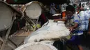 Seorang penjual membuat bedug untuk di jual di Jalan KH Mas Mansyur, Tanah Abang, Jakarta, Kamis (31/5). Bedug tersebut dijual dengan kisaran harga Rp 150 ribu hingga Rp 3 juta rupiah. (Liputan6.com/Arya Manggala)