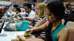 Peserta wanita saat membuat cerutu selama kelas master dalam Festival Havana Cigar ke-20 di Istana Konvensi di Havana, Kuba (28/2). (AFP Photo/Adalberto Roque)