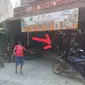 Pemilik Sapi (Baju Merah) Berusaha Mengevakuasi Sapi Ngamuk Masuk Kedai Roti (Tanda Panah Merah) di  Kawasan Pasar Rogojampi Banyuwangi. (Hermawan Arifianto/Liputan6.com)