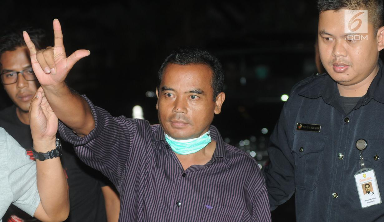 Bupati Purbalingga Tasdi (tengah) mengacungkan salam saat tiba di Gedung KPK, Jakarta, Selasa (5/6). Tasdi terjaring Operasi Tangkap Tangan KPK bersama lima orang lainya yakni sejumlah pejabat daerah Purbalingga dan pihak swasta. (Merdeka.com/Dwi Narwoko)