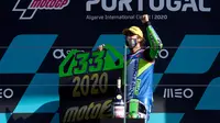 Pembalap Italtrans Racing Team, Enea Bastianini, merayakan keberhasilan menyabet gelar juara dunia Moto2 2020 di Sirkuit Portemao Portugal, Minggu (22/11/2020). (PATRICIA DE MELO MOREIRA / AFP)