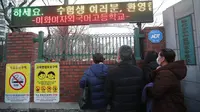 Para orangtua mengawasi anak-anak mereka menuju ujian masuk perguruan tinggi di depan sebuah sekolah menengah di Seoul, Korea Selatan, Kamis (3/12/2020). Pejabat Korea Selatan mendesak orang-orang untuk tetap di rumah selama ujian masuk perguruan tinggi. (AP Photo/Ahn Young-joon)