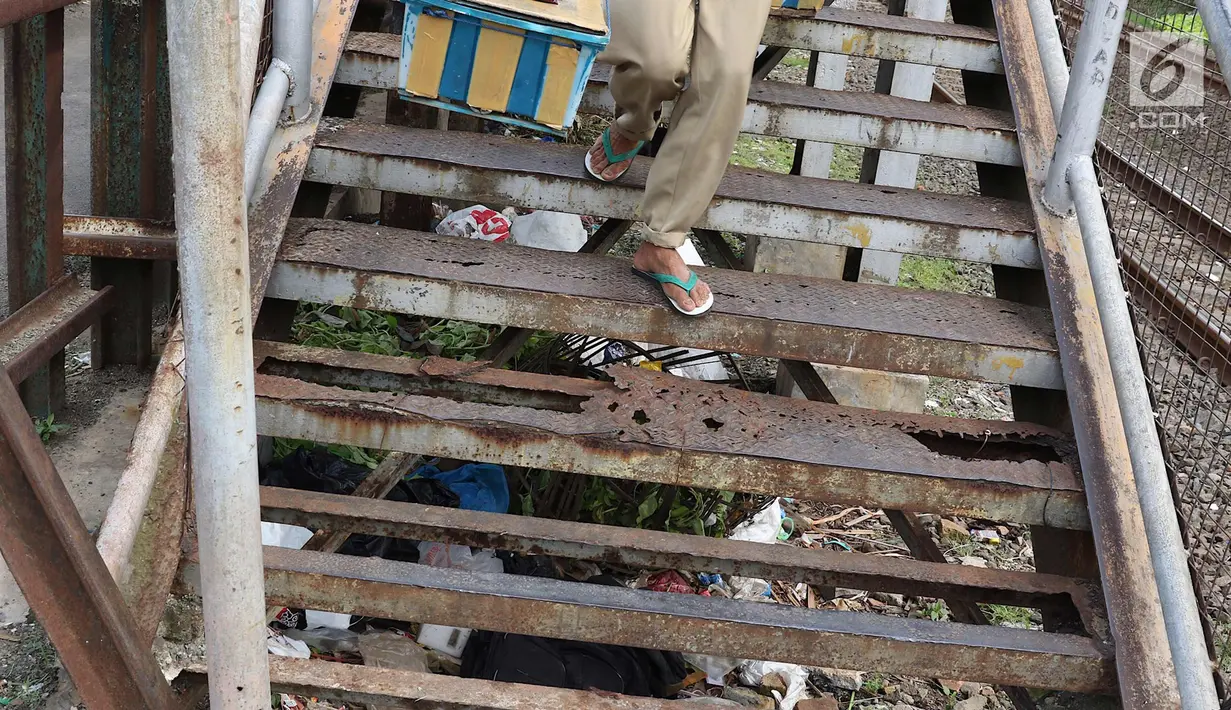 Warga menuruni tangga di JPO di kawasan Tebet, Jakarta, Selasa (6/3). Kondisi JPO yang memprihatinkan menyebabkan sebagian warga lebih memilih untuk tidak menggunakannya karena membahayakan keselamatan. (Liputan6.com/Immanuel Antonius)