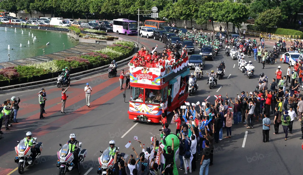 Warga antusias menyambut Tontowi Ahmad, Liliyana Natsir, Eko Yuli dan Sri Wahyuni saat parade dengan bus Bandros dari Bundaran HI menuju Istana Negara, Rabu (24/8/2016). (Bola.com/Nicklas Hanoatubun)