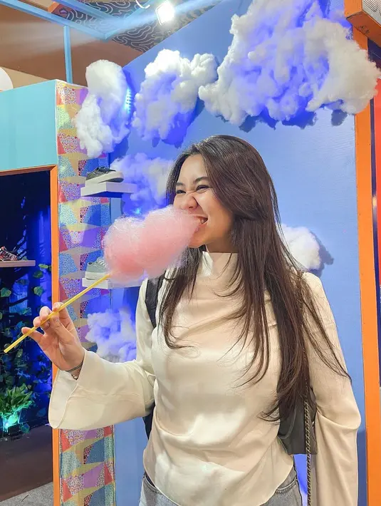 Jajan but make it chic. Aaliyah Massaid berpose makan gula-gula dengan outfit putih dan rambut panjangnya dibiarkan tergerai kasual. [Foto: Instagram/aaliyah.massaid]