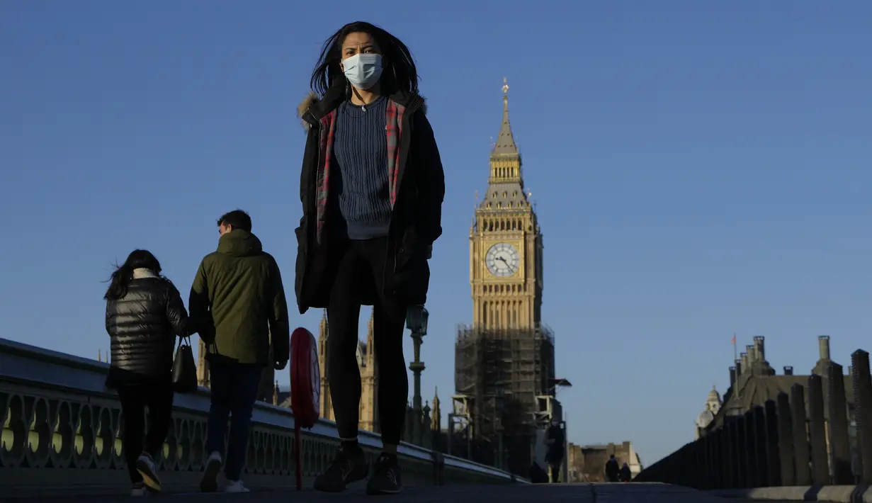 Orang-orang berjalan di atas Jembatan Westminster di London, pada Kamis (20/1/2022). Pemerintah Inggris mengakhiri pembatasan COVID-19, termasuk mandat masker, bekerja dari rumah dan paspor vaksin mulai Kamis. (AP Photo/Kirsty Wigglesworth)
