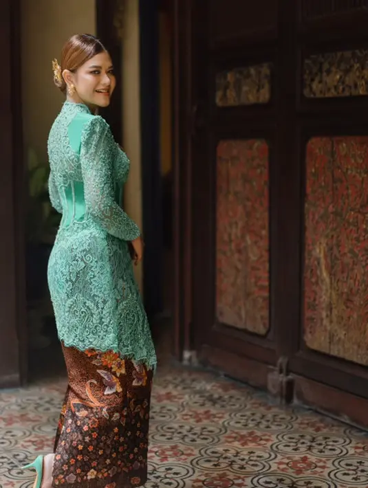 Ia memakai kebaya modifikasi hijau mint dengan detail tulang korset yang memperjelas siluet tubuh. Dipadukan dengan kain batik dan mules hijau mint [@ayanggkahiyang]