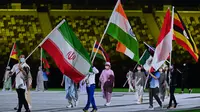 Atlet dan sukarelawan membawa bendera pada upacara penutupan Olimpiade Tokyo 2020. Sukarelawan membawa Bendera Indonesia. (AFP/Adek Berry)