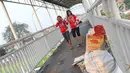Dua orang wanita melintas di jembatan penyeberangan orang di Jakarta, Minggu (6/8). Dinas Bina Marga DKI Jakarta akan merevitalisasi JPO dengan anggaran Rp10 miliar sesuai dengan APBD 2017. (Liputan6.com/Immanuel Antonius)