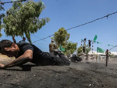 Sejumlah kadet Palestina melewati rintangan kawat berduri saat berlatih fisik dengan militer Hamas, Brigade Ezzedin al-Qassam, di Kota Gaza (20/7/2019). Sejumlah pemuda Palestina direkrut Hamas untuk menjadi bagian anggotanya. (AFP Photo/Mahmud Hams)