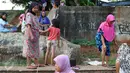 Sejumlah ibu bersama anaknya mencari ikan dan udang di bantaran Kanal Banjir Timur, Cipinang Muara, Jakarta, Selasa (16/5). Kegiatan itu dilakukan para ibu dan anak-anaknya untuk mengisi masa libur sekolah. (Liputan6.com/Immanuel Antonius)