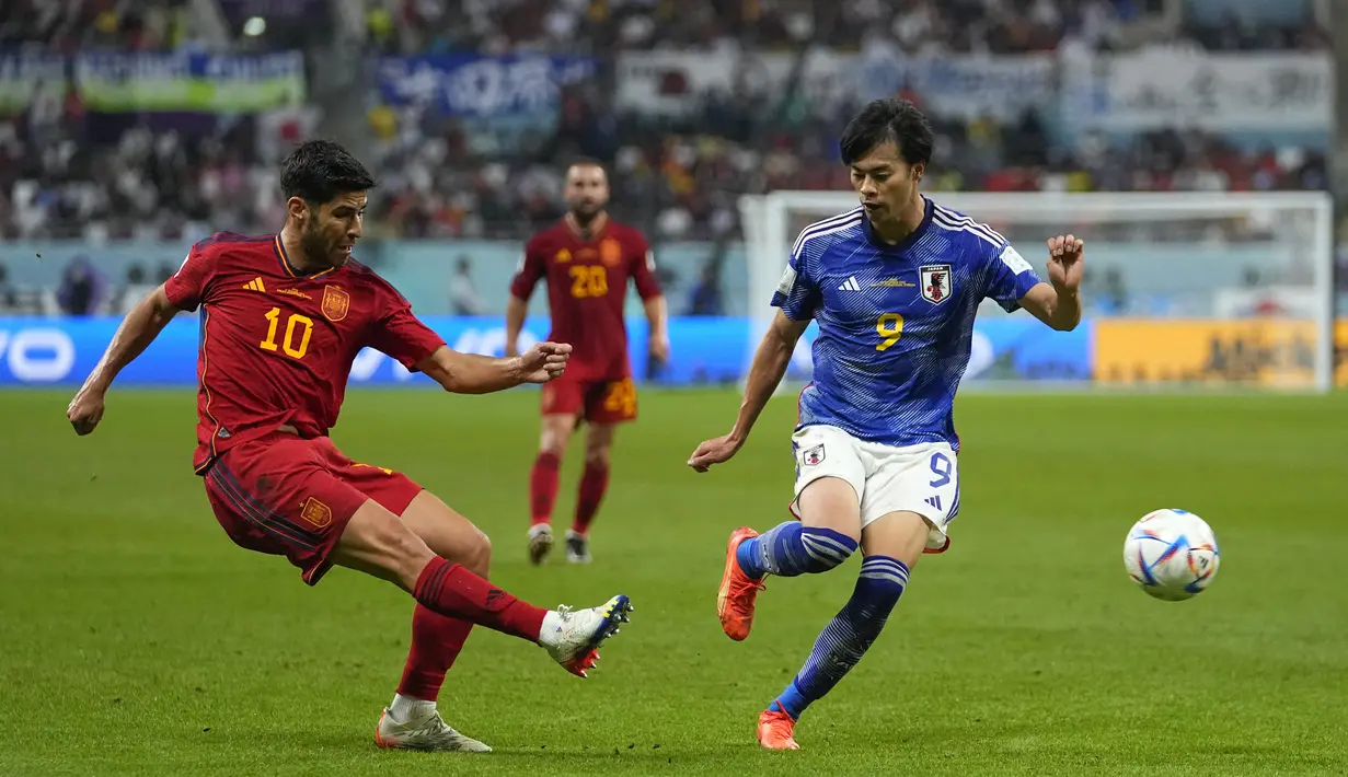 Gelandang Spanyol, Marco Asensio mengumpan bola dari kawalan pemain Jepang, Kaoru Mitoma selama pertandingan grup E Piala Dunia 2022 di Stadion Internasional Khalifa di Doha, Qatar, Jumat, 2 Desember 2022. Hasil ini membuat Jepang lolos ke babak 16 besar sebagai juara Grup E dengan enam poin. (AP Photo/ Julio Cortes)